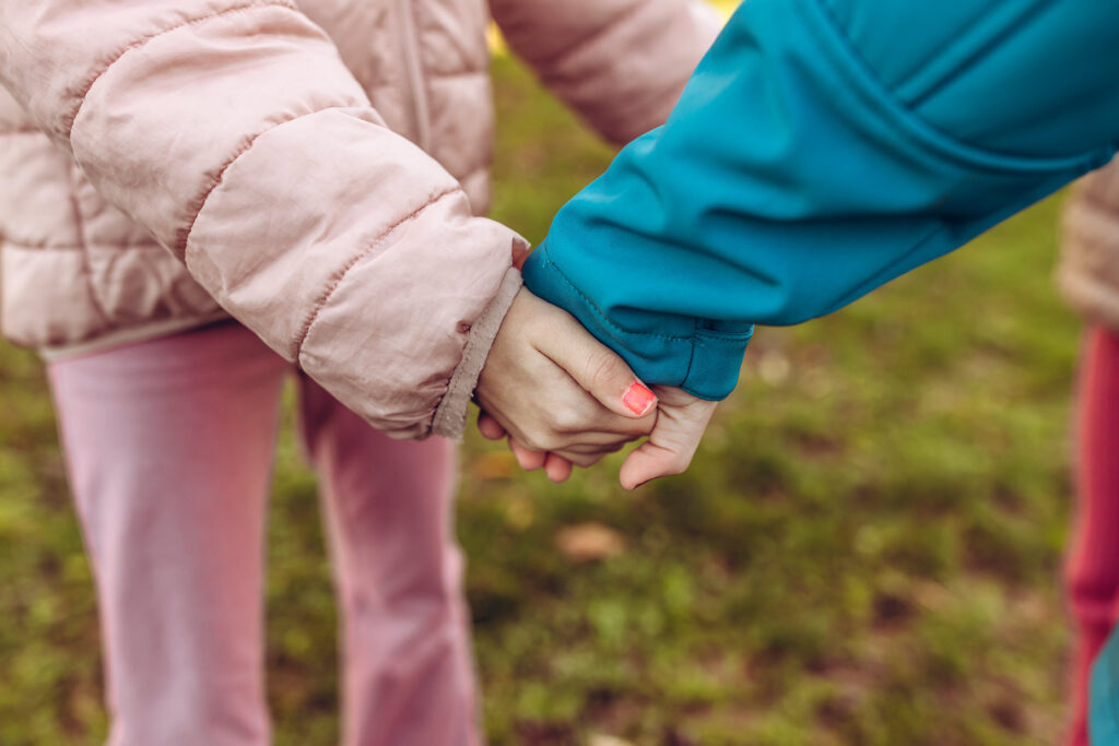 Zwei Kinder halten sich an den Händen