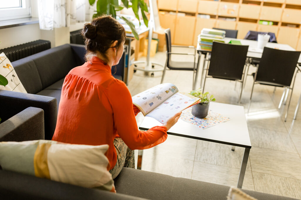Lehrerin arbeitet an einem Tisch in einem Aufenthaltsbereich