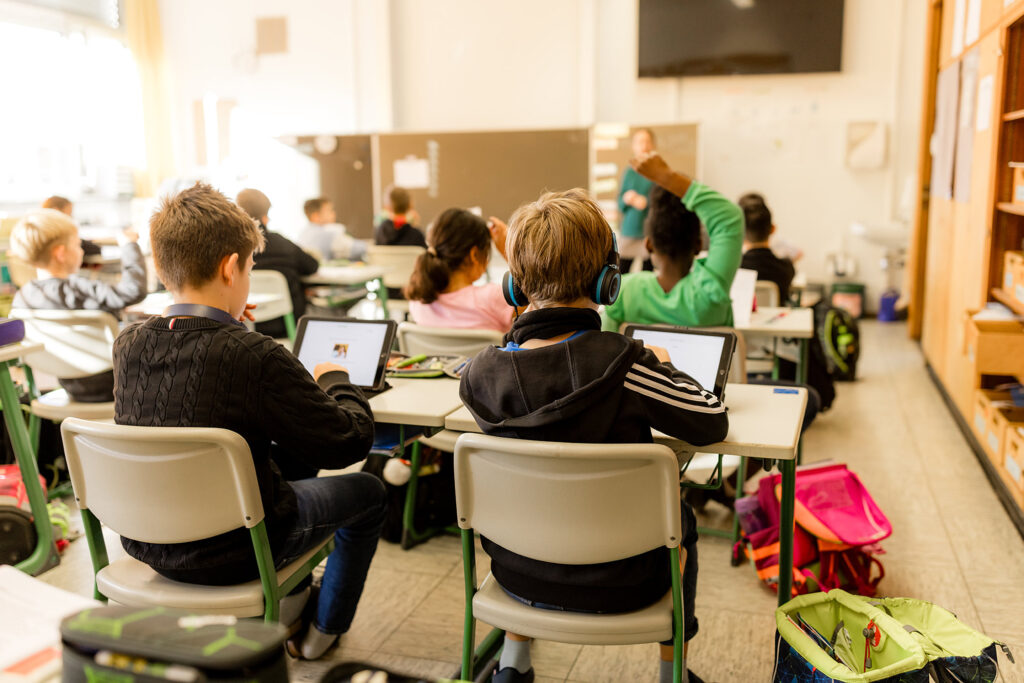 Kinder sitzen im Klassenzimmer und arbeiten gemeinsam