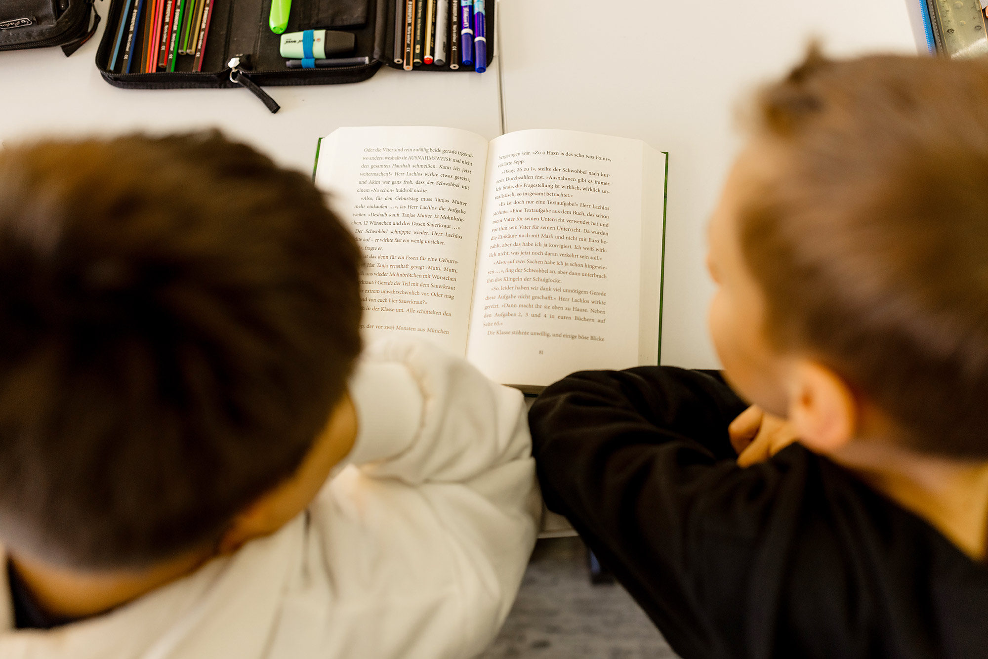 Zwei Kinder lesen zusammen in einem Buch