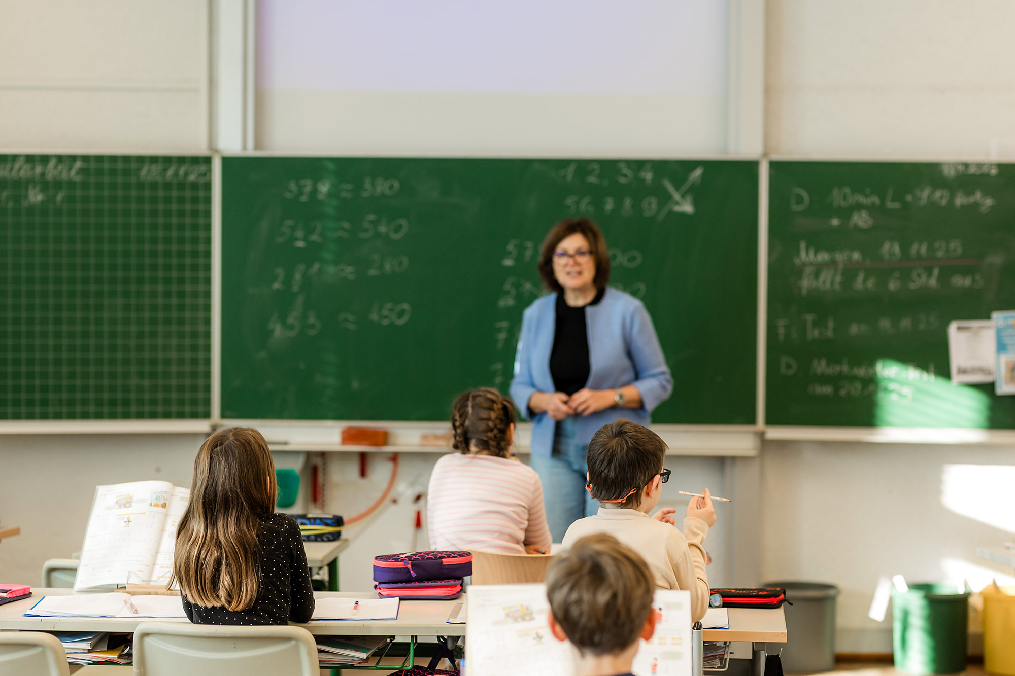 Kinder sitzen im Klassenzimmer und folgen dem Unterricht