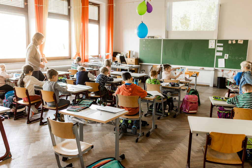 Kinder sitzen im Klassenzimmer und arbeiten an ihren Plätzen